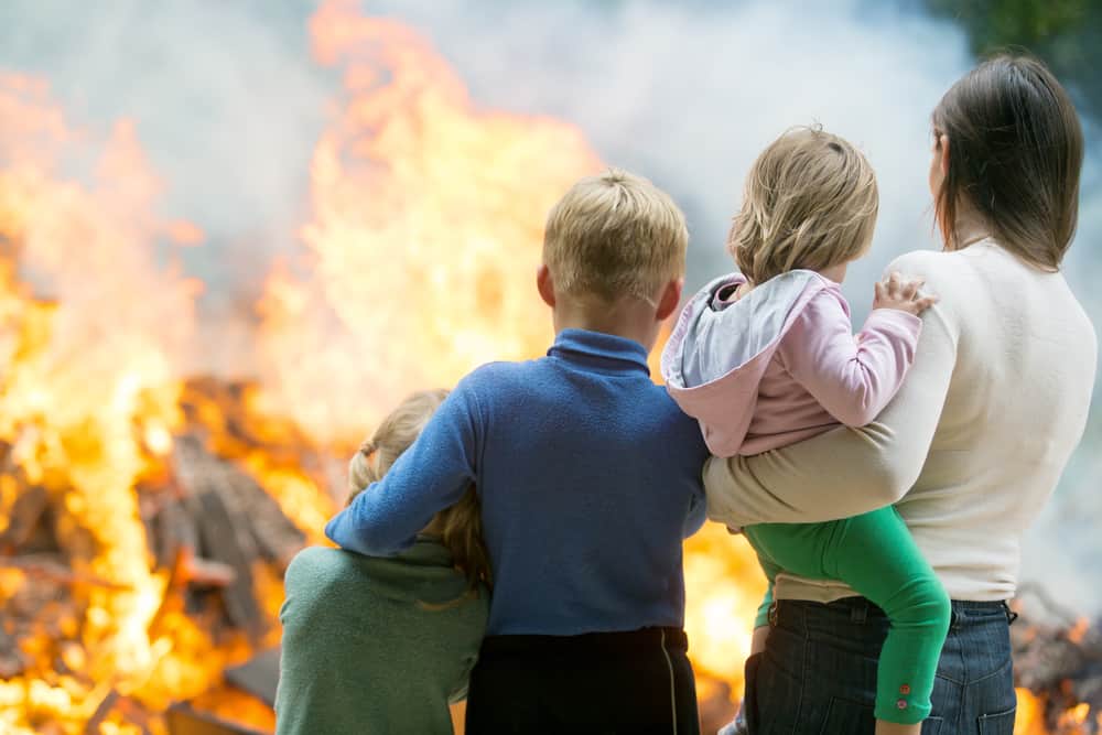 Family mother with children at burning house fire accident background
